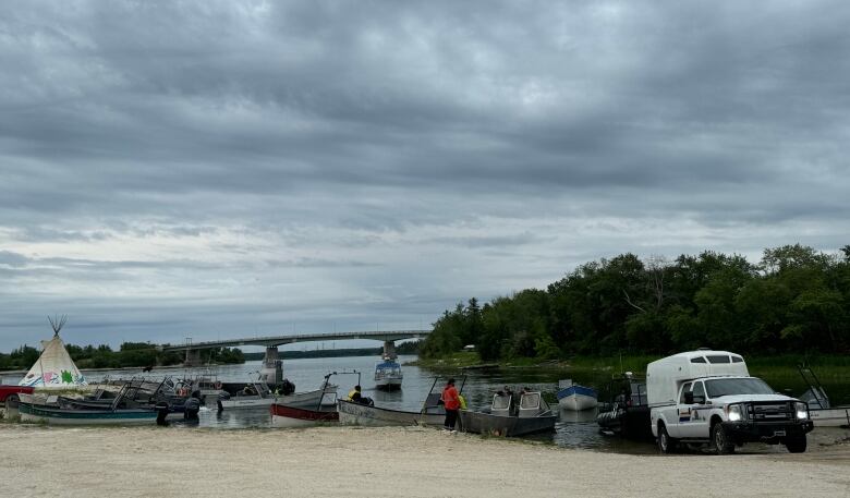 Several boats line the shore of a lake.