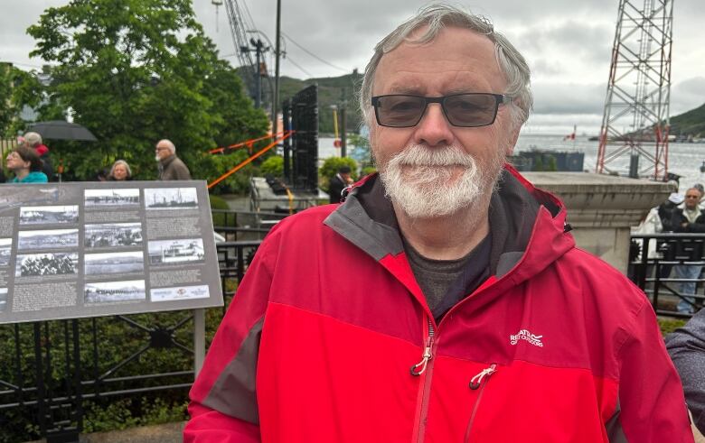 Man with red coat and sunglasses.