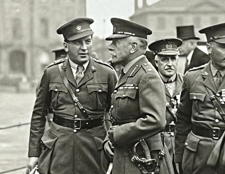 A black and white photo from the 1920s shows two men in uniform.