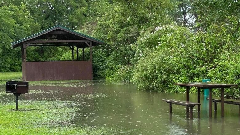 A camp ground with water pooling around an outdoor table