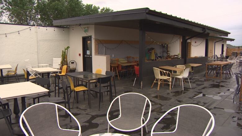 A restaurant patio is soaked in water after a rainstorm. 