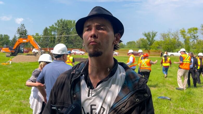 A man stands in front of a construction site.