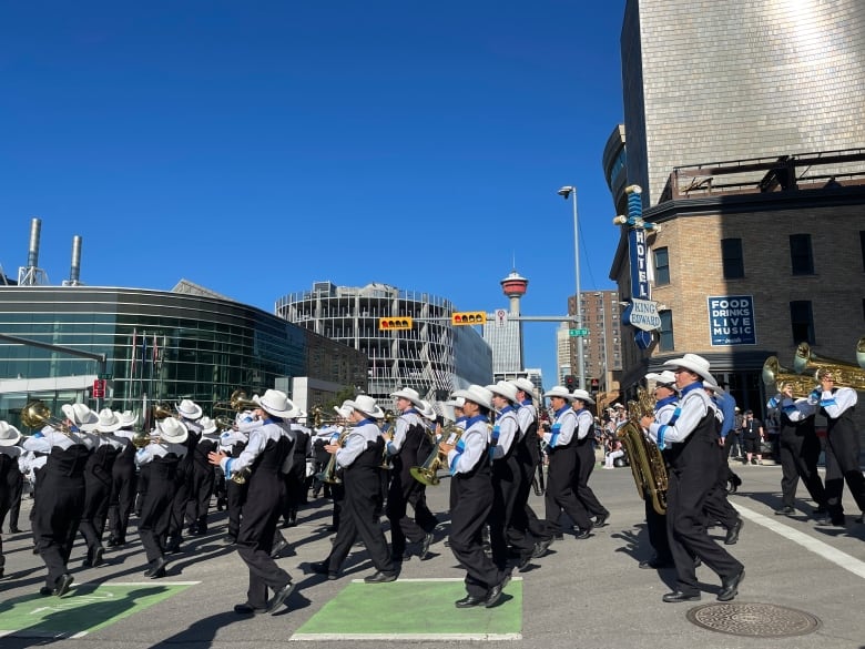 a marhcing band marches on a street on a sunny day 