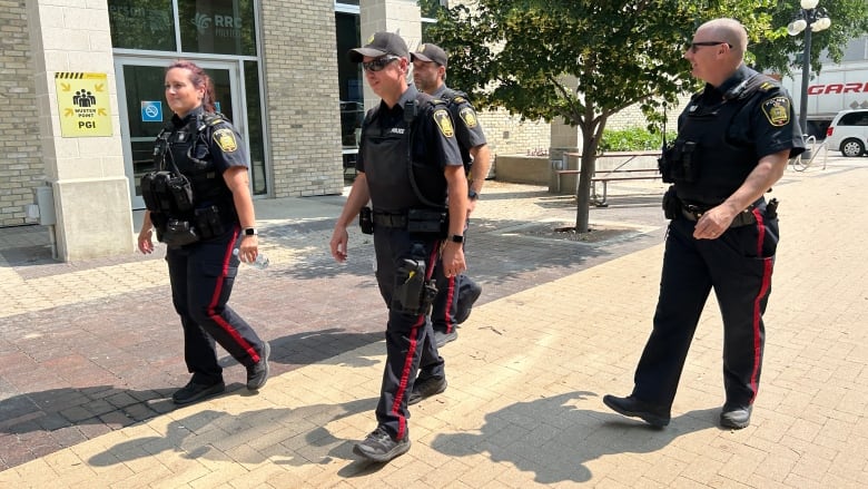 Four officers walk the foot patrol in summer