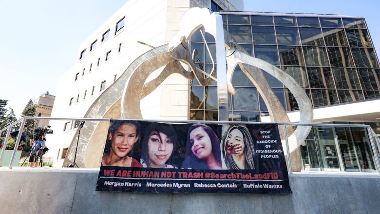 A banner of four women who were killed by a Winnipeg serial killer. 