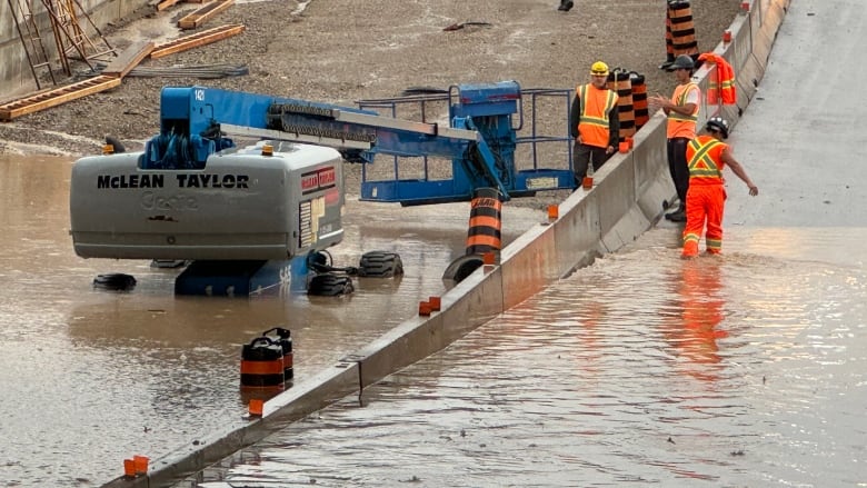 Employees wade through flooding at the Adelaide Street underpass. 