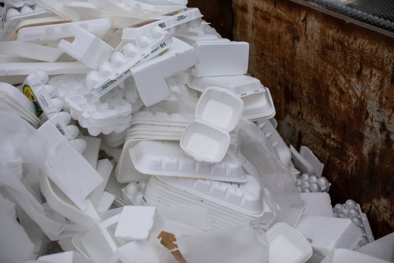 Stacks of plastic takeout containers are seen in a landfill.