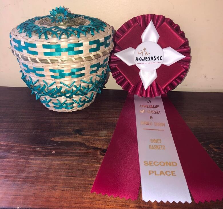 An ash basket with a ribbon next to it.