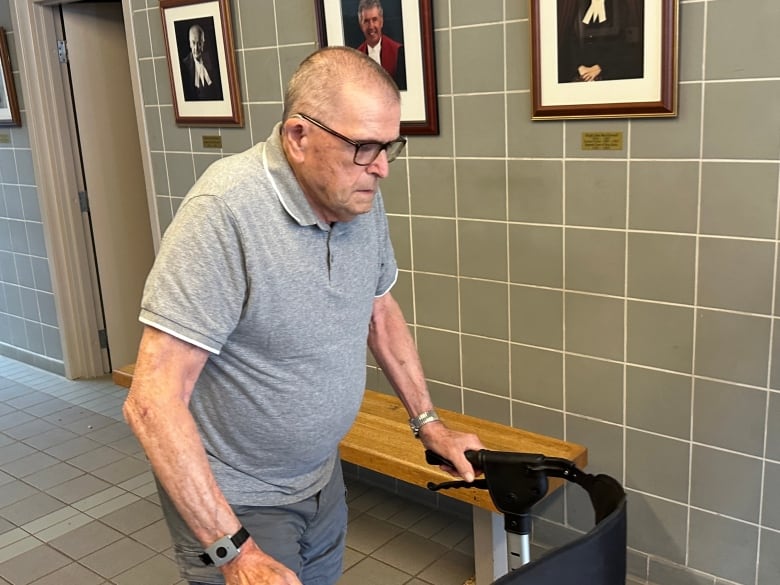 A man is shown pushing a walker inside a court building.