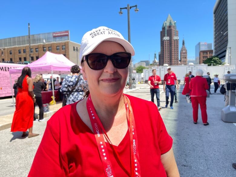 A woman wearing a white hat with the words Make America Great Again and a red t-shirt is pictured.