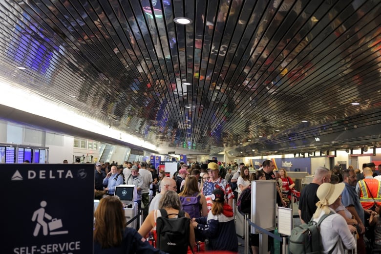 Passengers wait at Milwaukee Mitchell International Airport, after airlines grounded flights due to a worldwide tech outage caused by an update to CrowdStrike's 