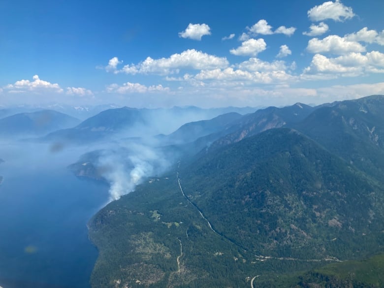 smoke coming from a fire next to a lake