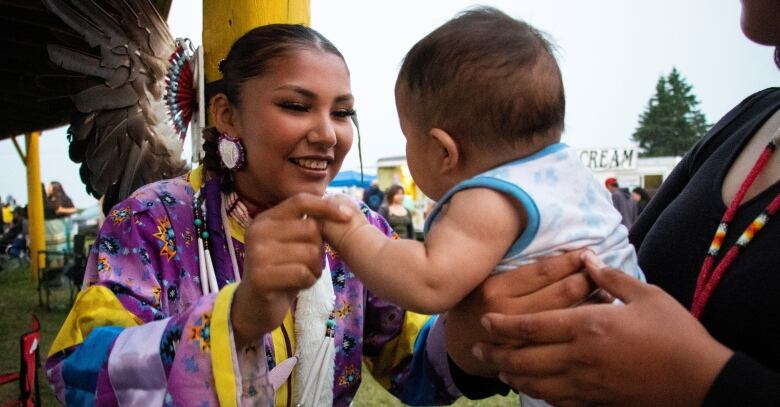 A woman smiling at a baby.