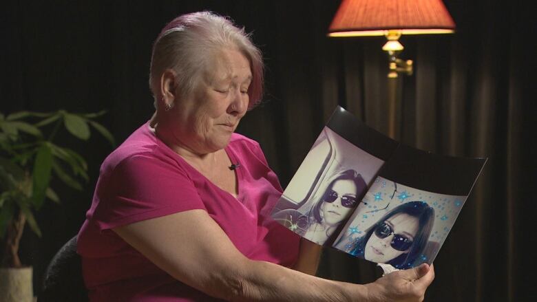 Woman with shirt hair holding up a photo of a young woman in sunglasses.