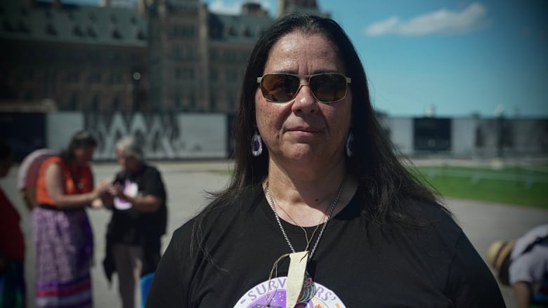 Laura Arndt, a woman, stands facing the camera.