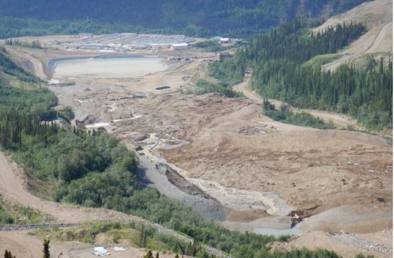 A slide of ore appears from the bottom right of the image extending to the upper right, where the lower Dublin south pond is pictured. That pond was built to hold mine contact water, but ore material also buried a section of the natural Dublin Gulch watercourse.