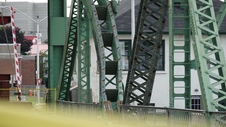 Two bent pieces of green metal are surrounded by other bridge elements.