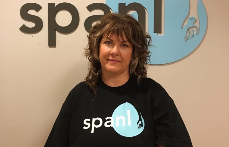 A woman wearing a black t-shirt with the Single Parent Association of Newfoundland and Labrador logo on it.