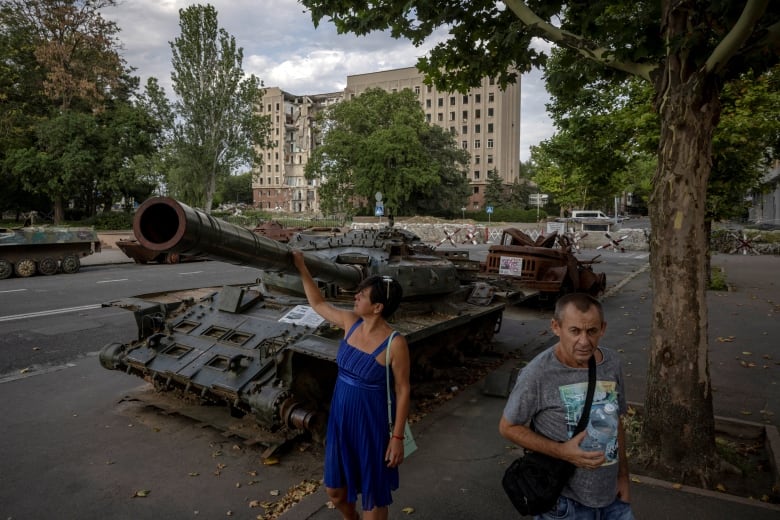 A woman examines a captured Russian tank on display in Mykolaiv, Ukraine, on Tuesday.