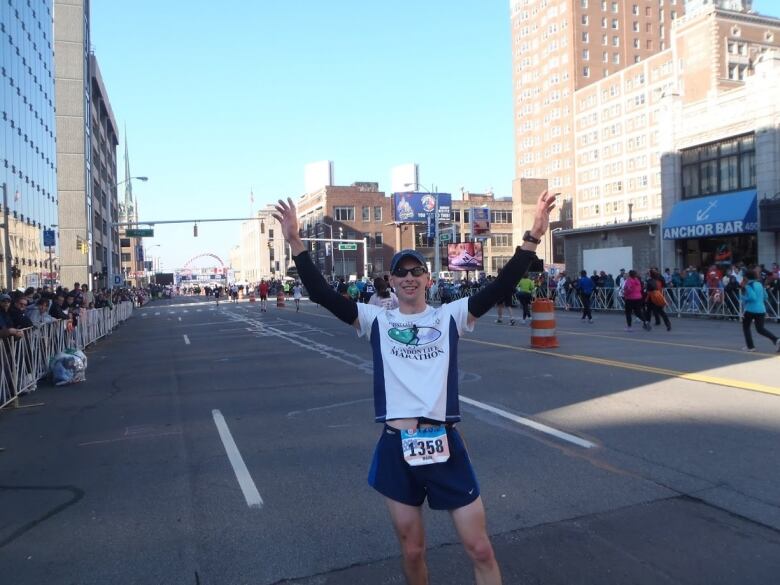 A happy runner posing while running the Detroit Free Press Marathon