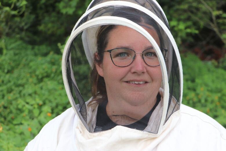 A woman wearing a bee mask smiles at the camera 