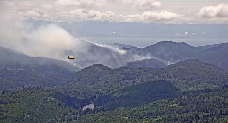 A plane flies near smokey hills