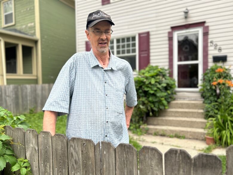 A man is standing in front of a house.