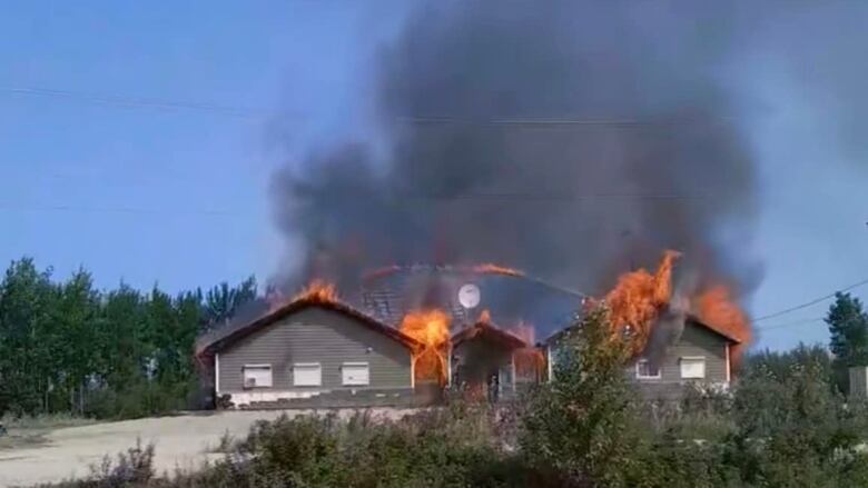 A building is seen on fire from a distance.