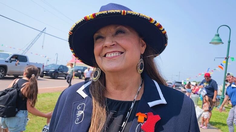 Close-up of woman smiling with activity behind her.