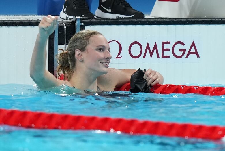 A female swimmer is seen celebrating in the pool.