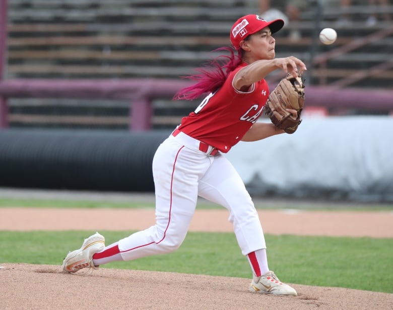 A woman pitches a baseball.