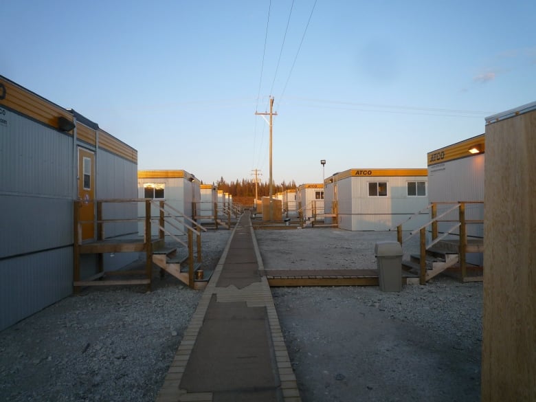 A row of white and yellow ATCO work trailers. 