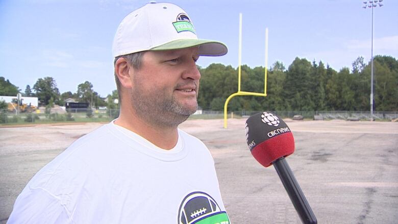 President of Football PEI, Stephen Letner, stands in front of a field.