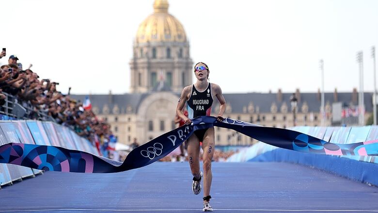 Cassandre Beaugrand of France crosses the line to win gold in the women's Olympic triathlon at Pont Alexandre III on July 31, 2024 in Paris. 