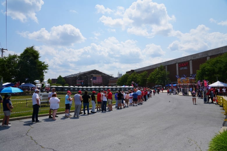 People line up outside an arena.