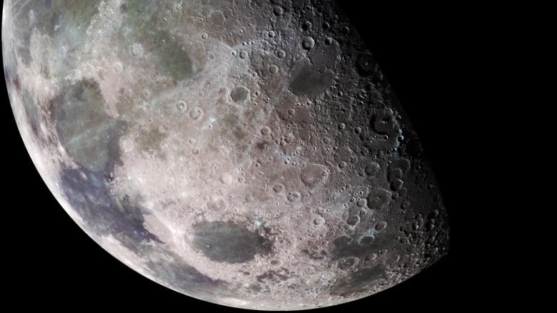 A quarter moon with its dark maria and craters.