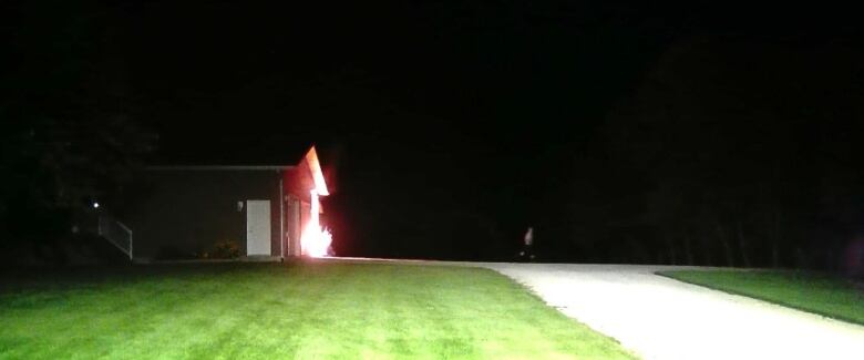 An attached garage burns in the night.