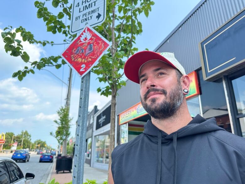 A man stands next to a piece of street art.