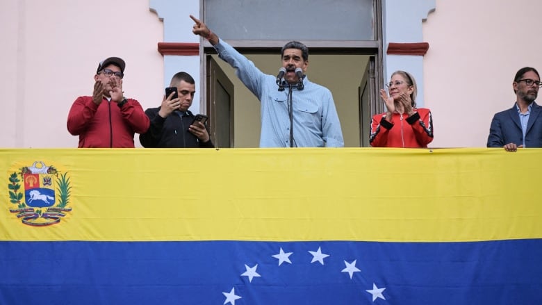 Venezuelan President Nicolas Maduro (C), accompanied by his wife Cilia Flores (C-R), delivers a speech to his supporters during a rally at the Miraflores presidential palace in Caracas on August 1, 2024.