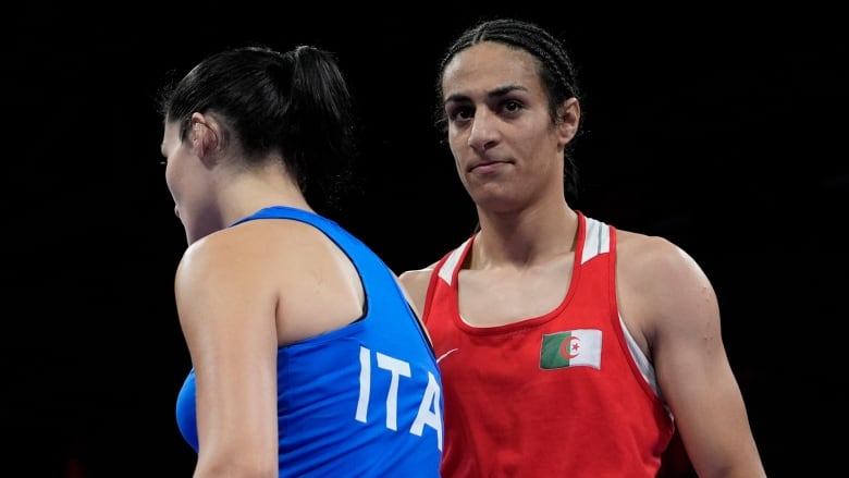 Women's boxers stand beside each other in the ring.