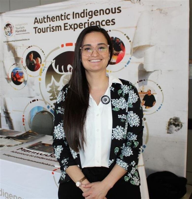 A person stands in front of a sign. 