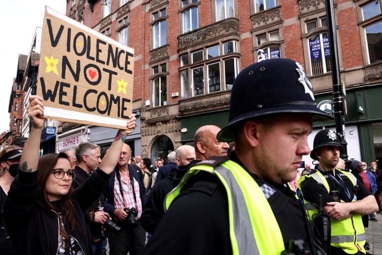 A person holds up a sign that read, 'Violence not welcome,' during a march.