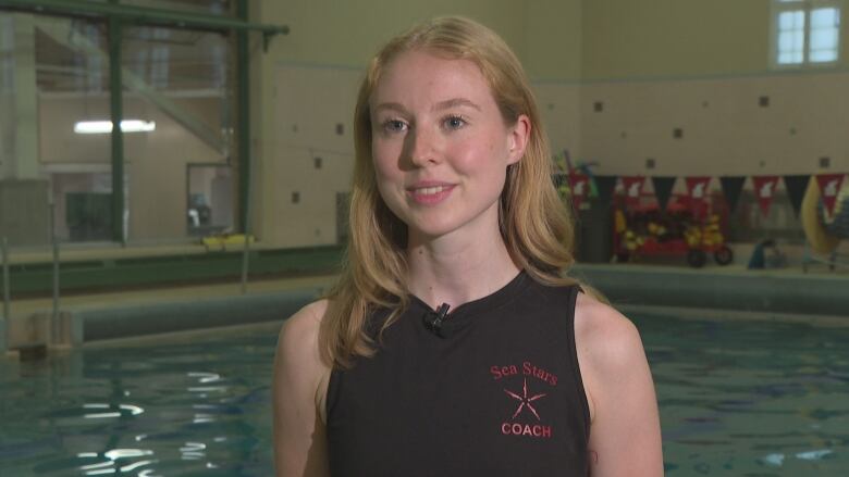 Woman with blonde hair smiles in front of pool