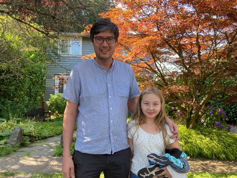 A man and a girl stand in front of a residence