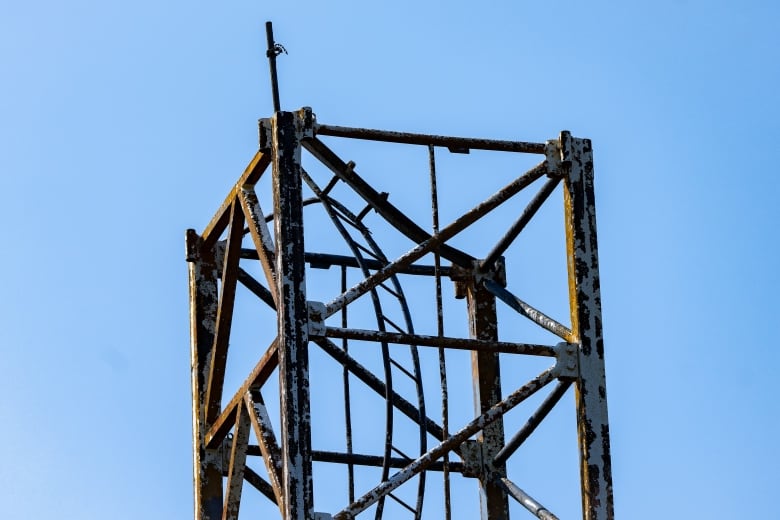 The base of a metallic structure is seen on a sunny day.