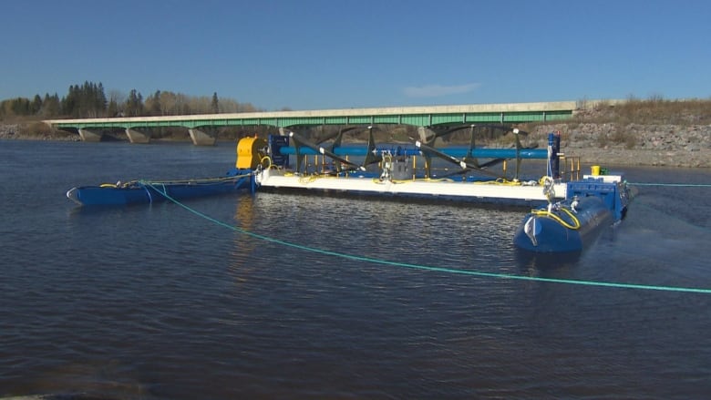 A device floating on the water. Two big blue pontoons, connected in the middle with a blade.