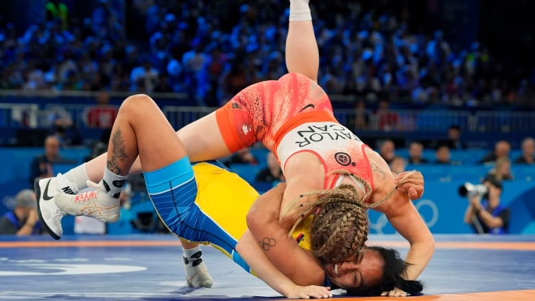 Two female wrestlers competing on the mat.