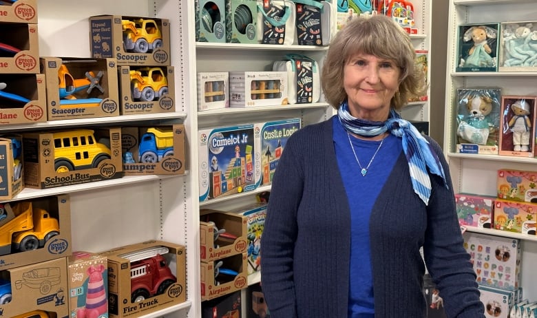 Monkeyshines manager Linda Dear in front of some bookshelves.