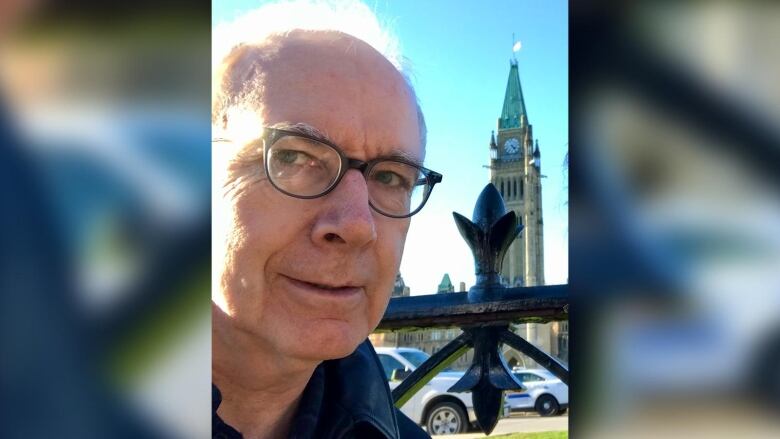 A man takes selfie in front of parliament.