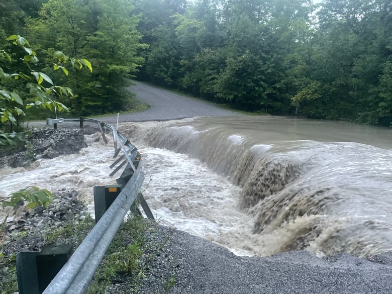 Water floods a rural road. 